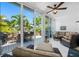 Relaxing sunroom with floor-to-ceiling glass doors and comfortable wicker furniture at 903 Pinellas Bayway S # 103, Tierra Verde, FL 33715