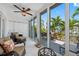 Bright sunroom with tiled floors, ceiling fan, and sliding glass doors to a deck overlooking the canal at 903 Pinellas Bayway S # 103, Tierra Verde, FL 33715