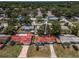 Aerial view of a single-story home with a red tile roof, surrounded by mature trees, and a well-maintained lawn at 9952 111Th St, Seminole, FL 33772
