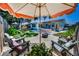 Relaxing backyard setting with lounge chairs, decorative umbrella, fire pit, and pebble ground cover at 9952 111Th St, Seminole, FL 33772