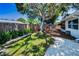 Landscaped backyard with a wooden bench, swing set, and white gravel area for activities and relaxation at 9952 111Th St, Seminole, FL 33772