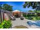 Cozy backyard with gravel, seating, fire pit, and an umbrella for shade, perfect for outdoor relaxation at 9952 111Th St, Seminole, FL 33772