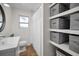 Bathroom includes a modern sink, toilet, tub and custom storage shelves with gray bins at 9952 111Th St, Seminole, FL 33772