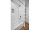 Bathroom featuring a white tub with subway tile surround and custom shelf storage at 9952 111Th St, Seminole, FL 33772