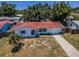 Charming home featuring a red tile roof, neat landscaping, and a driveway leading to an attached garage at 9952 111Th St, Seminole, FL 33772