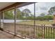 View of a large backyard with mature trees, as seen from the screened-in patio area at 3234 Morven Dr, Spring Hill, FL 34609
