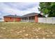 Exterior view of the back of the home with a large, fenced yard and screened-in patio at 3234 Morven Dr, Spring Hill, FL 34609
