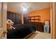 This bedroom features an orange accent wall, black curtains, dark wooden dressers and ceiling fan at 3234 Morven Dr, Spring Hill, FL 34609