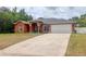 Charming single-story home with a two-car garage, arched entryway, and a spacious concrete driveway at 3234 Morven Dr, Spring Hill, FL 34609