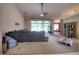 Spacious living room with carpet, ceiling fan, view of the enclosed patio, and an open layout at 3234 Morven Dr, Spring Hill, FL 34609
