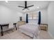 Bright bedroom with a ceiling fan, window, tile flooring, a wooden dresser and a wooden desk at 10038 62Nd N Ter # 17, St Petersburg, FL 33708