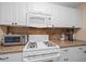 Well-maintained kitchen features white appliances, gas range, and complementing countertops with cabinets at 10038 62Nd N Ter # 17, St Petersburg, FL 33708