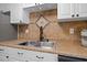 Stainless steel kitchen sink with decorative tile backsplash and updated faucet at 10038 62Nd N Ter # 17, St Petersburg, FL 33708