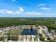 Beautiful aerial view of homes surrounding a pond with fountain in a lush, green community at 10205 Charleston Corner Rd, Tampa, FL 33635