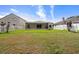 View of the grassy backyard with a screened in patio and white picket fence at 10205 Charleston Corner Rd, Tampa, FL 33635