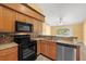 Eat-in kitchen with stainless steel appliances, granite countertops, and wood cabinets at 10205 Charleston Corner Rd, Tampa, FL 33635