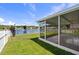 View of an enclosed lanai that overlooks a pond and surrounding lush backyard at 10205 Charleston Corner Rd, Tampa, FL 33635