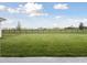 Spacious backyard featuring lush lawn, black metal fence, and views of the surrounding neighborhood at 10320 Longmeadow Ave, Parrish, FL 34219