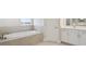 Bathroom showcasing a soaking tub, white cabinets and a white door at 10320 Longmeadow Ave, Parrish, FL 34219
