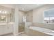 Elegant bathroom boasts double vanity, soaking tub, and glass shower at 10320 Longmeadow Ave, Parrish, FL 34219