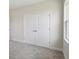 Bright bedroom featuring neutral walls and carpeting, along with closet doors at 10320 Longmeadow Ave, Parrish, FL 34219