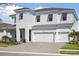 Beautiful two-story home featuring a spacious three-car garage and attractive modern architectural details at 10320 Longmeadow Ave, Parrish, FL 34219