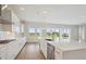 Well-lit kitchen with sleek countertops, stainless steel appliances, and expansive windows overlooking the backyard at 10320 Longmeadow Ave, Parrish, FL 34219