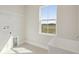 Bright laundry room featuring utility sink, tile flooring, window offering an outdoor view, and washer/dryer hookups at 10320 Longmeadow Ave, Parrish, FL 34219