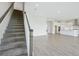 Elegant staircase leading to an open-concept living space, showcasing modern design and hardwood flooring at 10320 Longmeadow Ave, Parrish, FL 34219