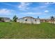 Wide angle of property showing green lawn, home exterior, and shed at 104 E Saint Johns Way, Apollo Beach, FL 33572