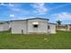 Exterior of home featuring metal siding, green lawn, and window with awning at 104 E Saint Johns Way, Apollo Beach, FL 33572