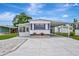 Exterior of well maintained home featuring carport, colorful shutters, and landscaping at 104 E Saint Johns Way, Apollo Beach, FL 33572