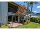 Back exterior features a blossoming tree, glass doors, and an enclosed balcony at 11201 122Nd Ave # 167, Largo, FL 33778
