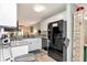 Modern kitchen with white cabinets, granite countertops, and black appliances at 11201 122Nd Ave # 167, Largo, FL 33778