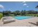 Community pool and sun loungers offer a great view of pond and landscaping at 11201 122Nd Ave # 167, Largo, FL 33778