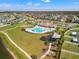 Aerial view of the community pool and recreation center with large green space and a playground at 11508 Sage Canyon Dr, Riverview, FL 33578
