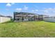 Lush green backyard with in-ground pool and screened enclosure with outdoor seating at 11508 Sage Canyon Dr, Riverview, FL 33578