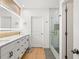 Modern bathroom featuring an illuminated mirror, white cabinets with stylish dark hardware, and glass shower at 11508 Sage Canyon Dr, Riverview, FL 33578