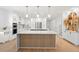 A modern, eat-in kitchen with white cabinets, stainless steel appliances, and a stylish wood-paneled island at 11508 Sage Canyon Dr, Riverview, FL 33578
