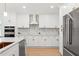 Elegant kitchen with marble countertops, stainless steel appliances, and white cabinetry for a modern aesthetic at 11508 Sage Canyon Dr, Riverview, FL 33578
