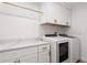 Well-organized laundry room with modern washer and dryer, countertop space, and ample storage cabinets at 11508 Sage Canyon Dr, Riverview, FL 33578