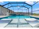 Inviting in-ground pool with two lounge chairs in the water and poolside seating, fully screened in at 11508 Sage Canyon Dr, Riverview, FL 33578