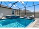 Beautiful in-ground pool and spa with screened enclosure and poolside furniture on the paver patio at 11508 Sage Canyon Dr, Riverview, FL 33578
