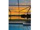 Gorgeous sunset view of the backyard pool and lake at 11508 Sage Canyon Dr, Riverview, FL 33578