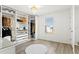 A spacious walk-in closet featuring custom shelves, drawers, and a bright chandelier at 11508 Sage Canyon Dr, Riverview, FL 33578