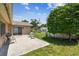 Backyard with a concrete patio, lawn, mature tree, and a garden in the background at 11746 93Rd Ave, Seminole, FL 33772