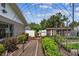 Backyard garden featuring a metal archway, raised beds, and a chicken coop at 11746 93Rd Ave, Seminole, FL 33772
