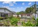 Backyard garden area with raised garden beds, greenery, and a chicken coop at 11746 93Rd Ave, Seminole, FL 33772