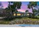 Charming single-story home surrounded by lush palm trees and a twilight sky at 123 14Th Ave, Indian Rocks Beach, FL 33785