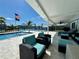 Inviting back patio with stylish seating area, a sparkling pool and views of the serene waterfront at 12300 4Th E St, Treasure Island, FL 33706
